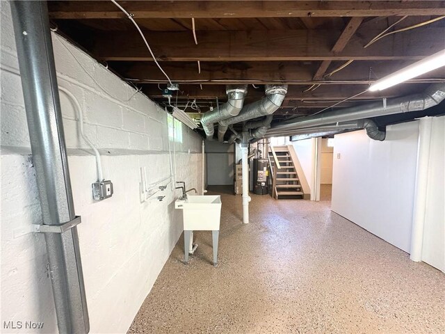 19708 Sunset Dr, Warrensville Heights, OH 44122 - below grade area with water heater, stairway, a sink, and concrete block wall