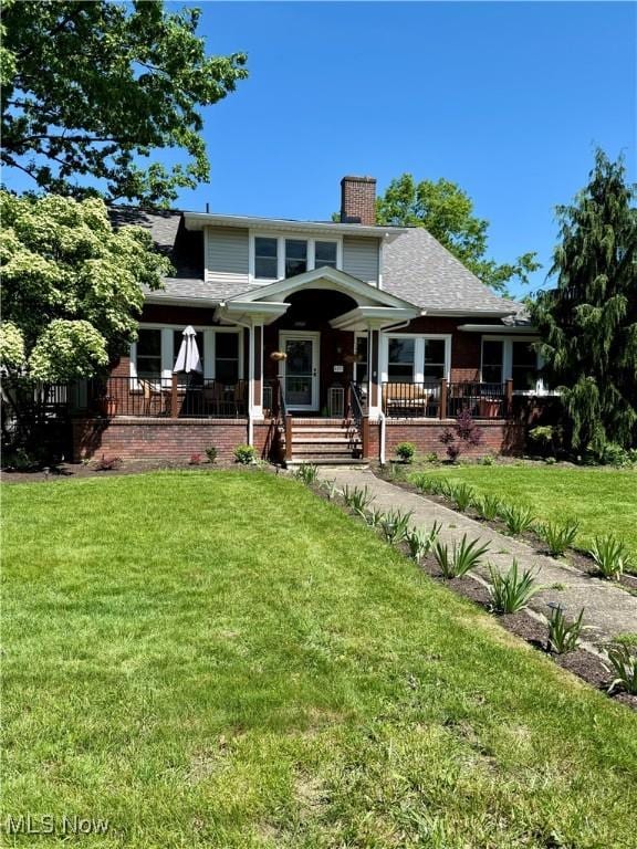 8471 Nowlen St, Mentor, OH 44060 - view of front of house with a chimney, a front yard, and covered porch