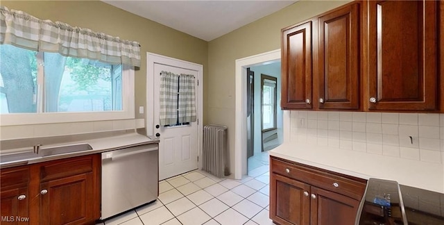 8471 Nowlen St, Mentor, OH 44060 - kitchen featuring stainless steel dishwasher, radiator heating unit, light countertops, and light tile patterned floors