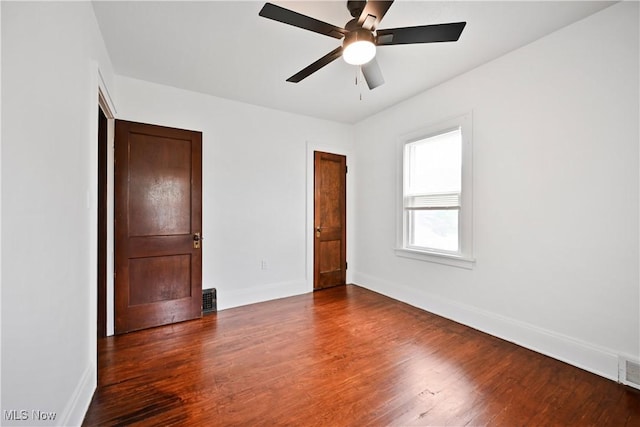 unfurnished bedroom with baseboards, wood finished floors, and a ceiling fan