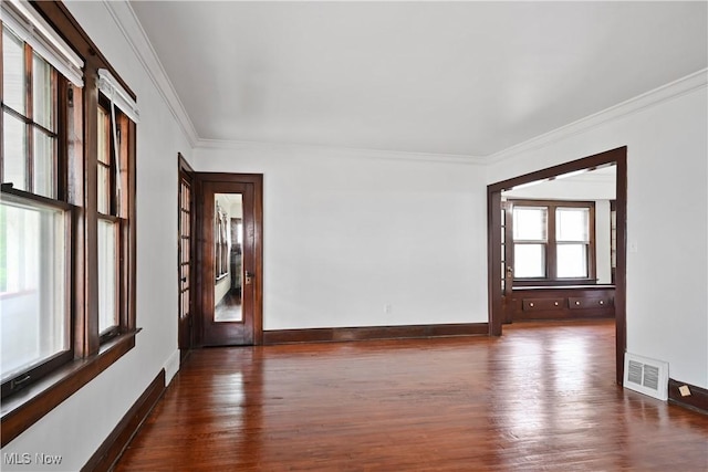 unfurnished room with dark wood finished floors, crown molding, and baseboards