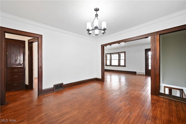 unfurnished room with a chandelier, ornamental molding, wood finished floors, and baseboards