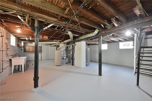 basement with gas water heater and a sink
