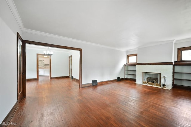 unfurnished living room featuring a chandelier, dark wood-style floors, ornamental molding, plenty of natural light, and baseboards
