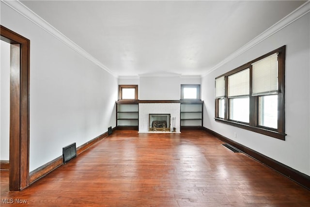 unfurnished living room featuring wood finished floors, a fireplace, ornamental molding, and baseboards