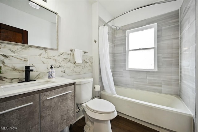 full bath with toilet, vanity, shower / bathtub combination with curtain, wood finished floors, and tile walls