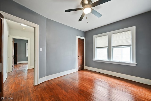 unfurnished room featuring baseboards, hardwood / wood-style flooring, and a ceiling fan