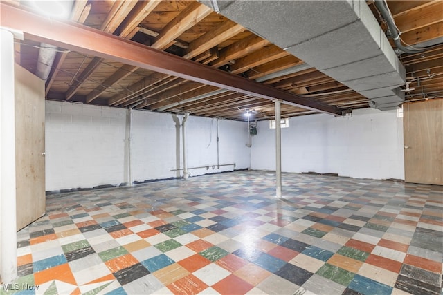 below grade area with tile patterned floors and concrete block wall