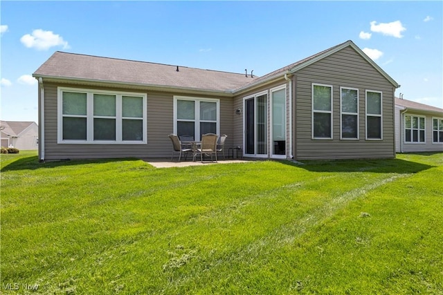 back of property with a patio area and a yard
