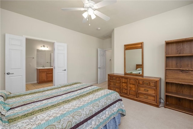 bedroom with a ceiling fan, connected bathroom, light carpet, and baseboards