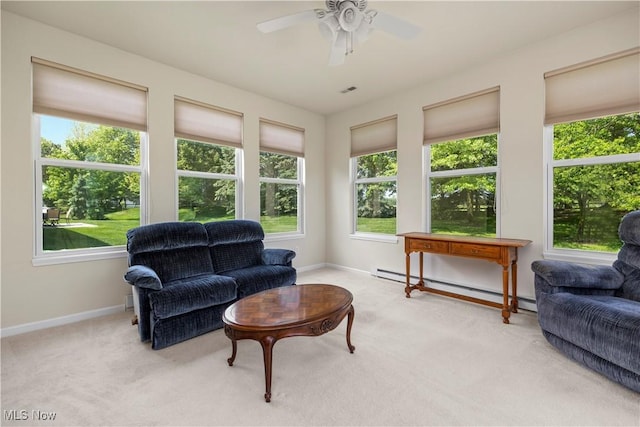 living area with baseboard heating, carpet flooring, baseboards, and ceiling fan