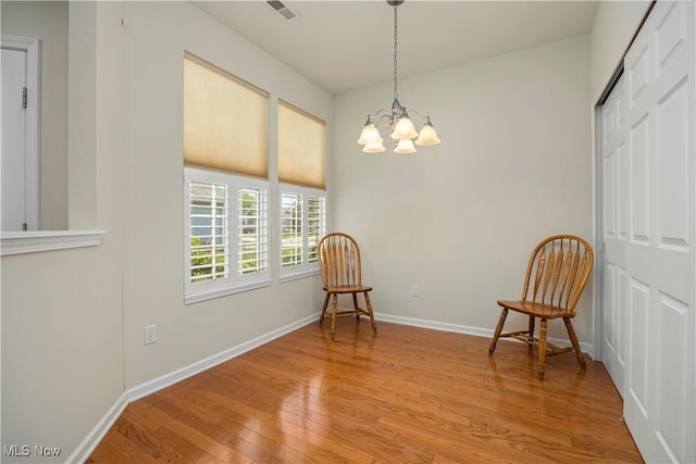 sitting room featuring light wood-style floors, a chandelier, and baseboards