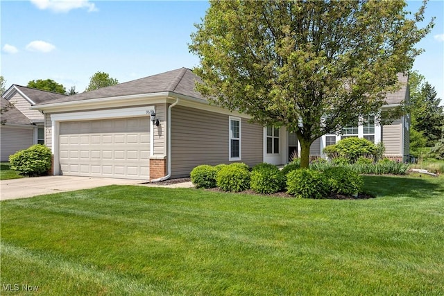 view of front of house with an attached garage, concrete driveway, and a front lawn