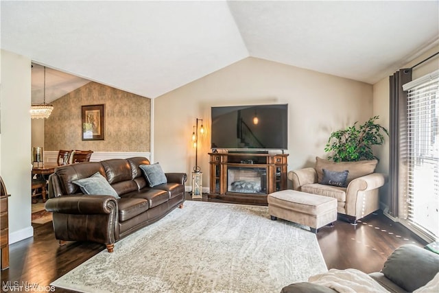 37 Monticello Dr, Brunswick, OH 44212 - living area featuring dark wood-type flooring, lofted ceiling, a chandelier, and a glass covered fireplace