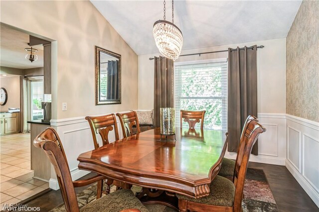 37 Monticello Dr, Brunswick, OH 44212 - dining area with vaulted ceiling, a chandelier, a wainscoted wall, and a decorative wall