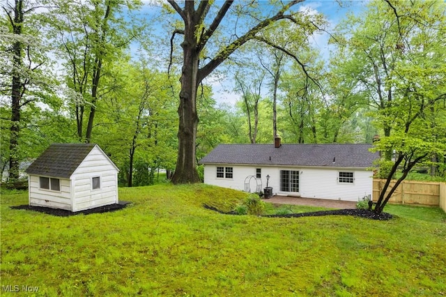 rear view of house with a patio, an outdoor structure, a storage shed, and a chimney
