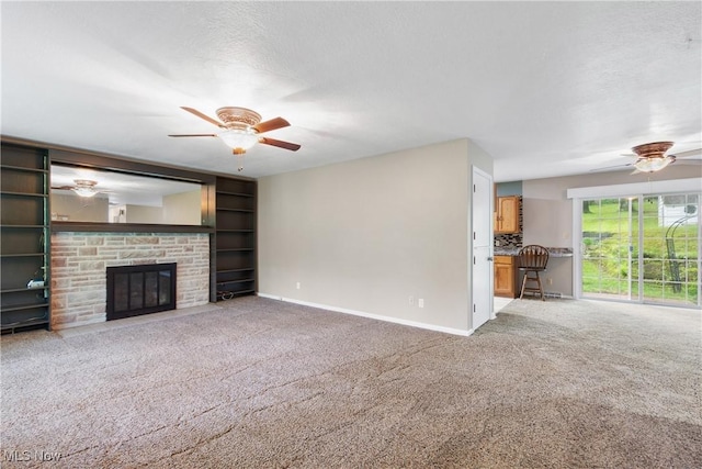 unfurnished living room featuring ceiling fan, carpet flooring, baseboards, and a fireplace