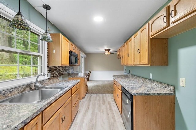 kitchen with a sink, black appliances, ceiling fan, light wood-type flooring, and decorative light fixtures