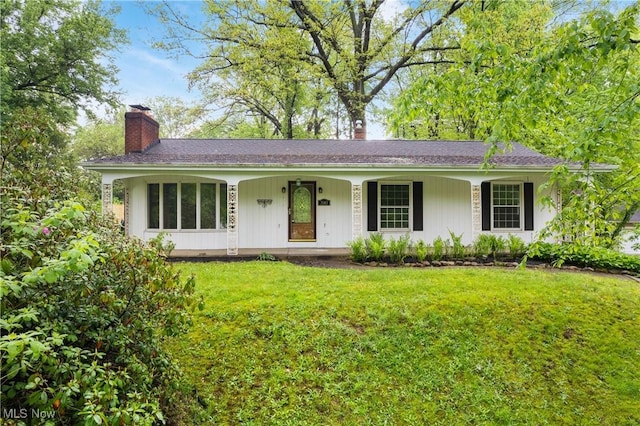 ranch-style home with a chimney, a porch, and a front yard