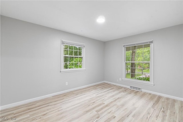 empty room with light wood finished floors and baseboards