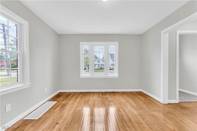 563 E 260th St, Euclid, OH 44132 - empty room featuring plenty of natural light, wood finished floors, and baseboards