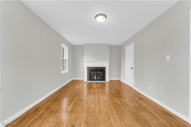563 E 260th St, Euclid, OH 44132 - unfurnished living room featuring a fireplace, light wood-style flooring, and baseboards