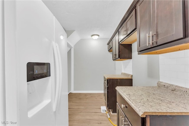 563 E 260th St, Euclid, OH 44132 - kitchen with white refrigerator with ice dispenser, dark brown cabinets, decorative backsplash, light wood-style floors, and light countertops