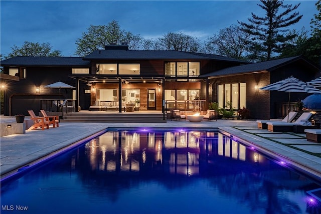 2471 Snowberry Ln, Pepper Pike, OH 44124 - rear view of house with a patio, an outdoor pool, and a bar