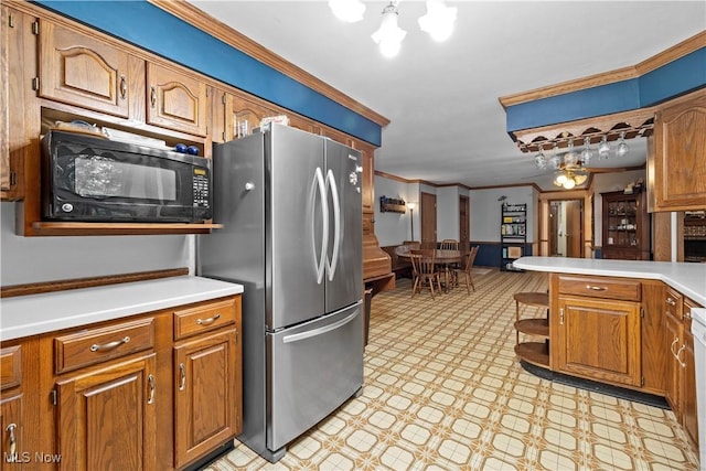 41972 Griswold Rd, Elyria, OH 44035 - kitchen featuring freestanding refrigerator, black microwave, brown cabinetry, light floors, and a chandelier