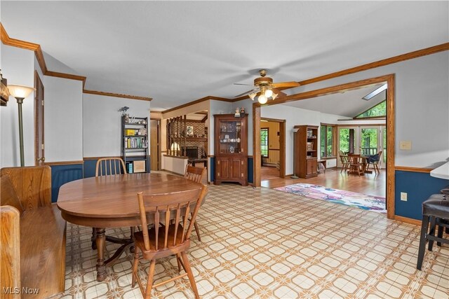 41972 Griswold Rd, Elyria, OH 44035 - dining area featuring a ceiling fan, a brick fireplace, lofted ceiling, light flooring, and ornamental molding