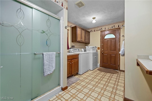 41972 Griswold Rd, Elyria, OH 44035 - laundry area featuring washer and dryer, light floors, cabinet space, baseboards, and a textured ceiling