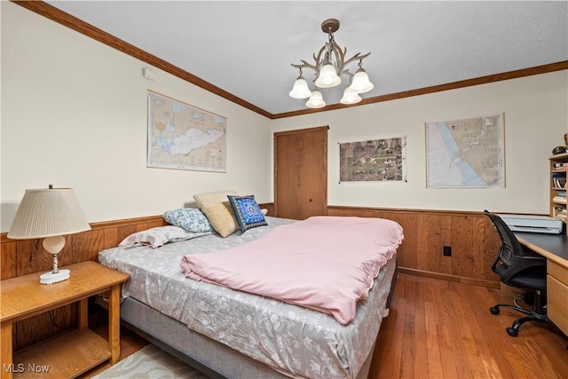41972 Griswold Rd, Elyria, OH 44035 - bedroom with wainscoting, wood-type flooring, a chandelier, ornamental molding, and a desk