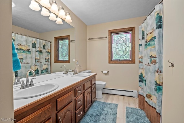 41972 Griswold Rd, Elyria, OH 44035 - full bath featuring baseboard heating, wood finished floors, double vanity, toilet, and a shower with curtain