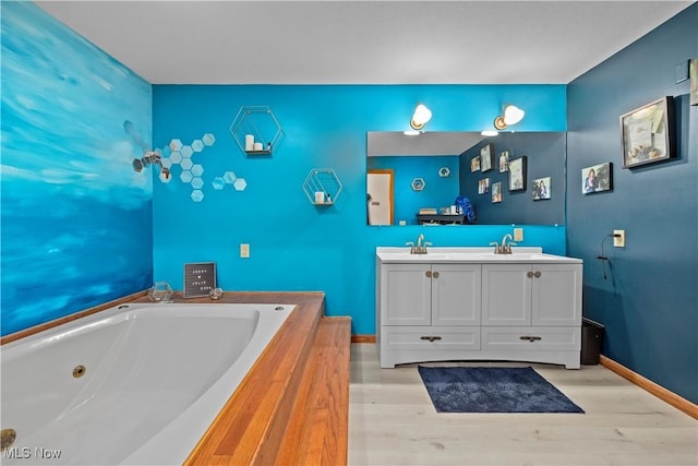 41972 Griswold Rd, Elyria, OH 44035 - full bath featuring double vanity, a tub with jets, wood finished floors, and baseboards