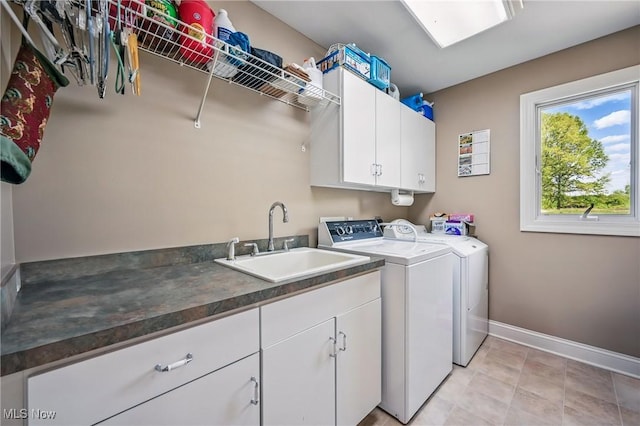 washroom featuring separate washer and dryer, cabinet space, and baseboards