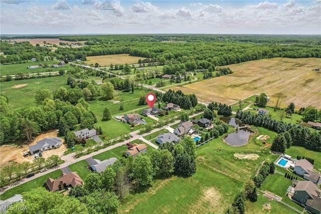 aerial overview of property's location with a large body of water, a heavily wooded area, and rural landscape