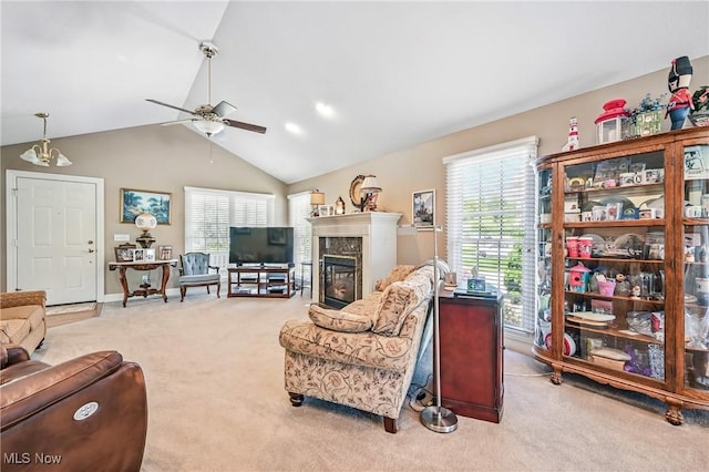 living room with light carpet, a glass covered fireplace, ceiling fan, and vaulted ceiling