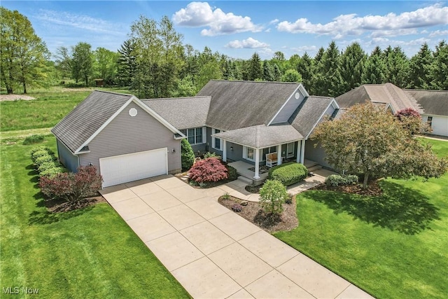 view of front facade with an attached garage, a front yard, a porch, driveway, and a shingled roof