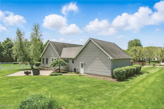 back of house featuring a patio area and roof with shingles