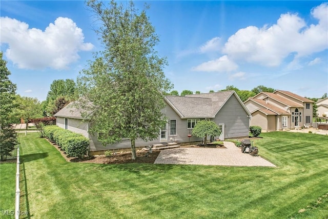 rear view of house with a patio and a lawn