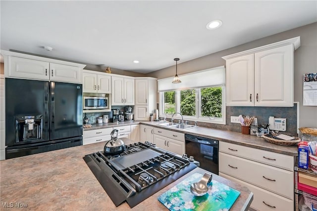 kitchen featuring black appliances, a sink, white cabinets, backsplash, and recessed lighting