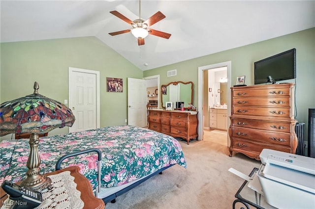 bedroom featuring light carpet, lofted ceiling, ceiling fan, and ensuite bathroom