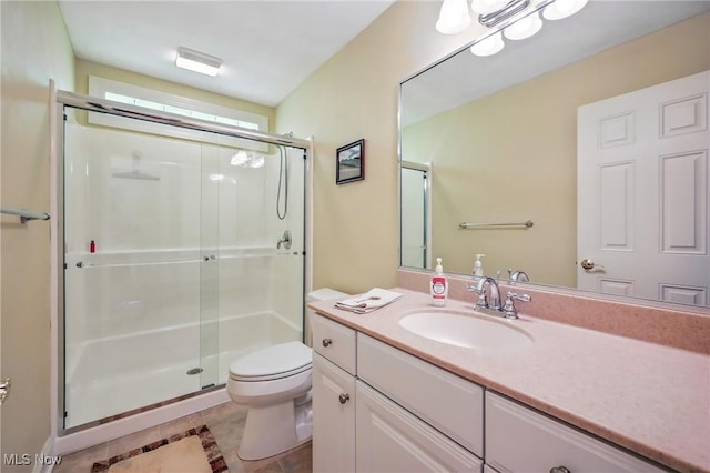 full bath with a stall shower, toilet, tile patterned floors, and vanity