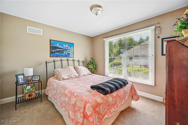 bedroom with light colored carpet and baseboards