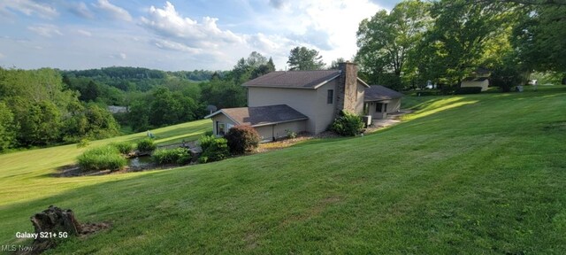 61426 Stillmeadow Ln, New Concord, OH 43762 - view of property exterior featuring a lawn and a chimney