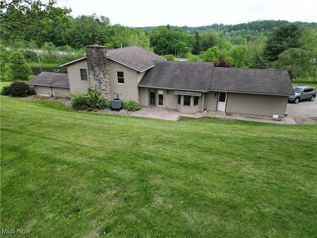 61426 Stillmeadow Ln, New Concord, OH 43762 - back of house with a yard, a chimney, a patio, and roof with shingles
