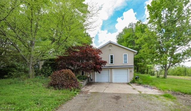 4217 State Route 82, Mantua, OH 44255 - view of side of home with driveway, a garage, and a yard