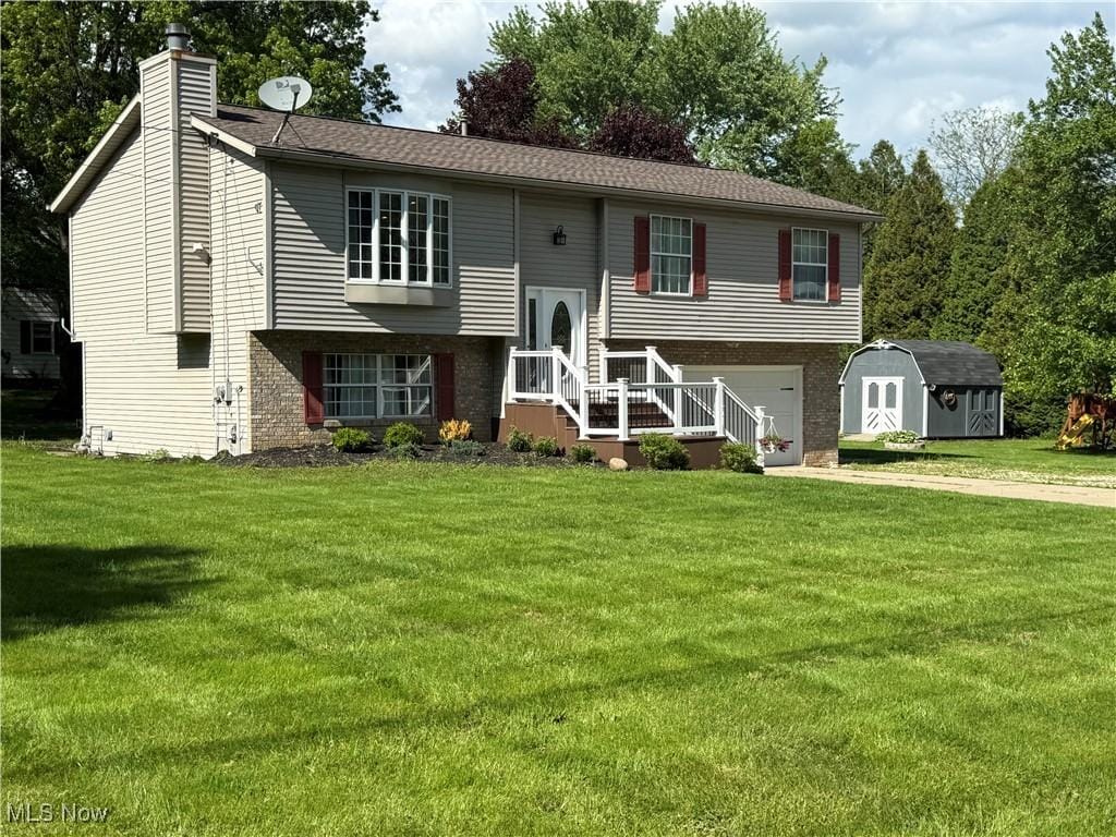 2579 Wealthy Dr, Copley, OH 44321 - split foyer home with a chimney, a storage shed, a garage, brick siding, and a front yard
