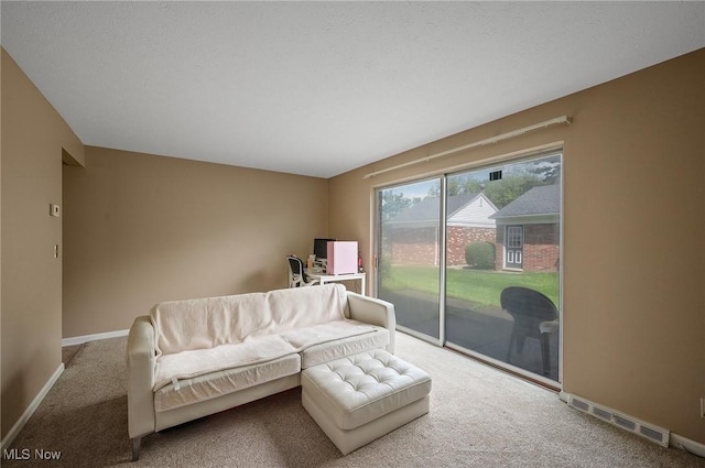 carpeted living room featuring baseboards