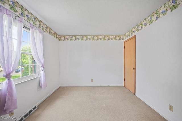 unfurnished room featuring light colored carpet and baseboards